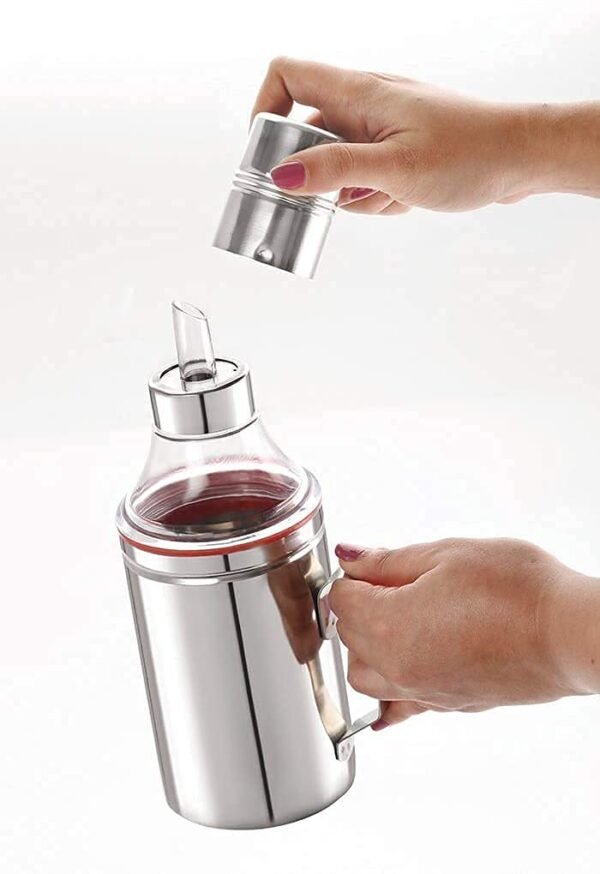 oil dispenser with handle in hand on white background