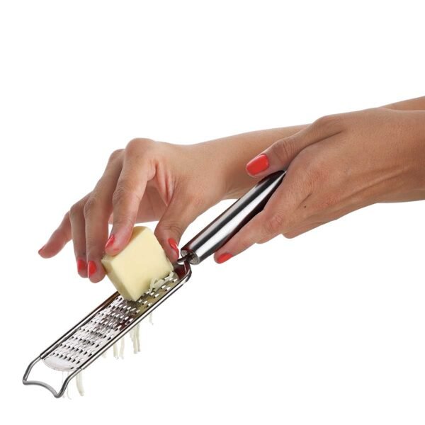 Stainless steel cheese grater grating cheese on white background