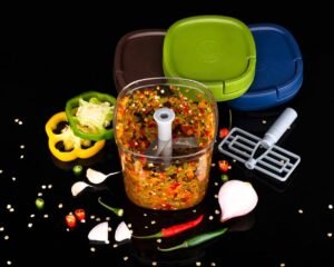 chopped vegetables with manual chopper on table