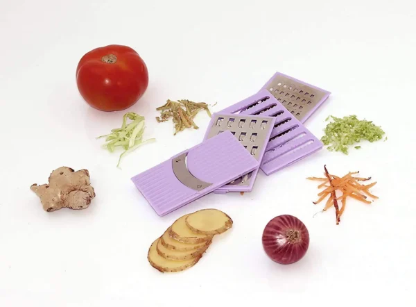 different types of blades of multipurpose slicer grater on white background with vegetables