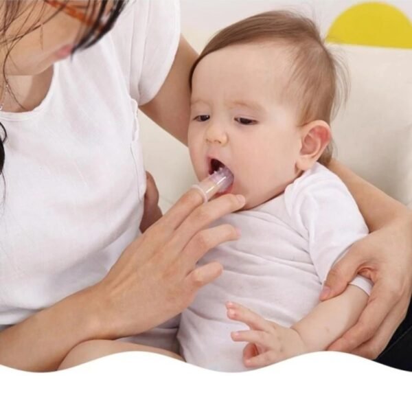 Women cleaning baby teeth from silicone finger brush