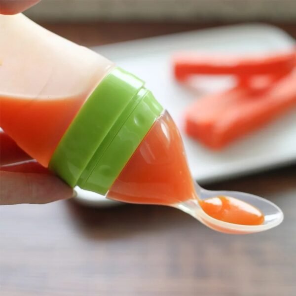 Pouring baby food in spoon from silicone bottle