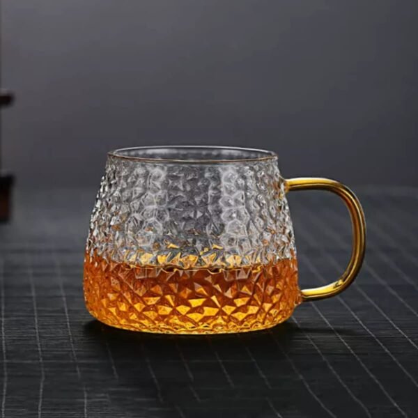 Golden Handle glass coffee mug filled with green tea on floor