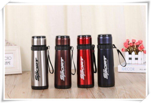 Different color sports vacuum flask on decorative background