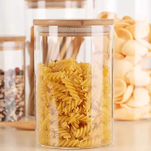 Transparent Bamboo lid glass storage container jar on decorative background having noodles in it