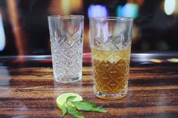 Diamond cut glass water glasses set on decorative with leaf and lemon slice on decorative background