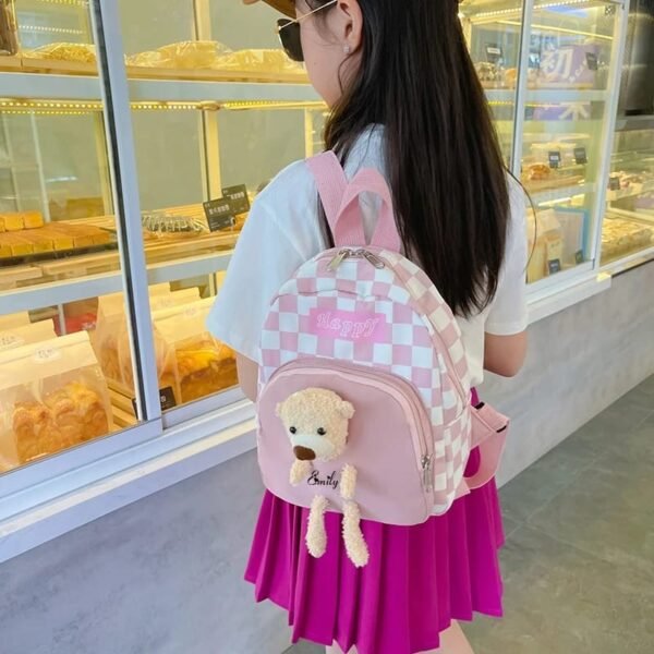 Pink color school bags hanging on baby girls shoulder