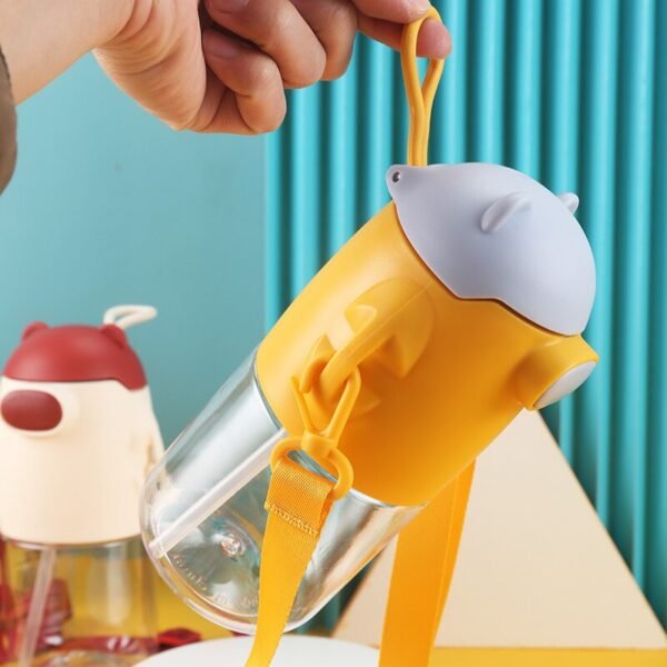 Yellow color plastic sipper with silicone handling band in hand
