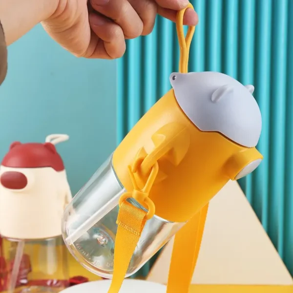 Yellow color plastic sipper with silicone handling band in hand