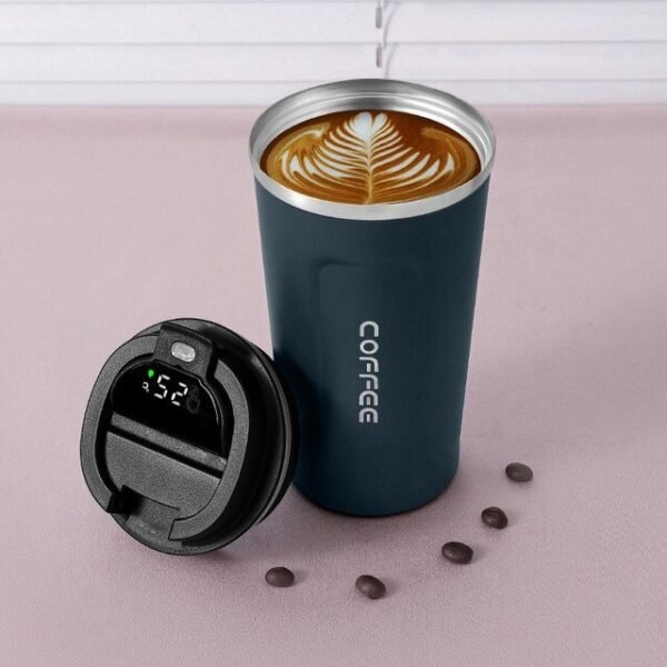Black color coffee mug filled with coffee with temperature display on floor