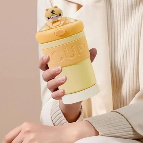 cute water glass bottle hold on hand yellow color on decorative background
