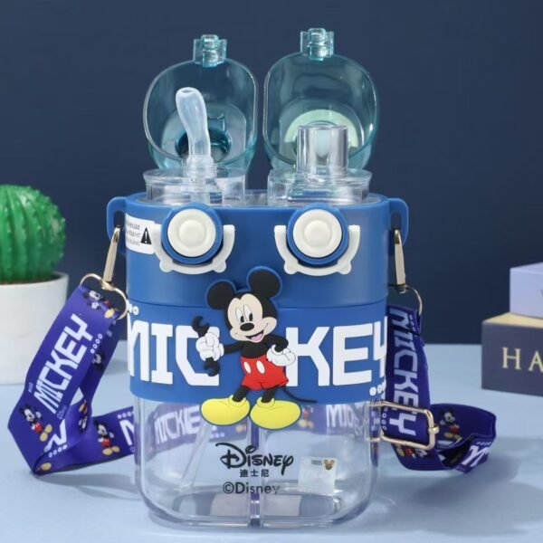 A close up of a blue double water bottle featuring a Mickey Mouse character on the top. It has a shoulder strap and dual shipping function one is with straw and other one for direct sipping with the words "Mickey" and "Disney" Printed on it. Placed on table with two books in the background