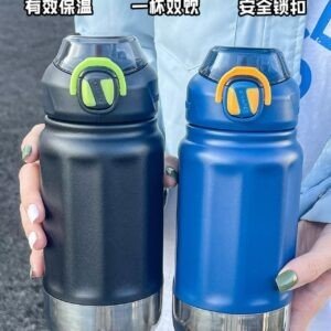 A person holding two water bottles side by side. The bottles are black and blue with stainless steel base and matching color lids.