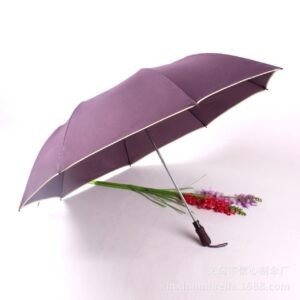 Fully opened solid purple umbrella with a light colored trim with flowers on white background