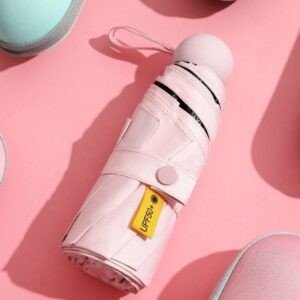 Pink portable umbrella with UPF 50+ rating for effective sun blocking, shown folded on pinkish background.
