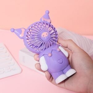 A hand holds a purple portable fan shaped like a cartoon character, demonstrating its handheld size against a pink background.