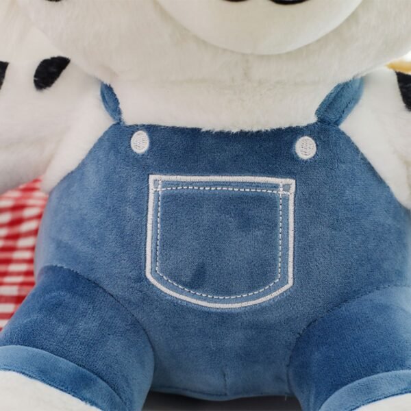 Soft tiger plush stuffed animal torso detail, showing white fur with black spots and textured blue corduroy-style denim bib overalls.