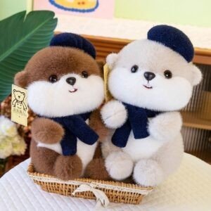 Two adorable plush stuffed animals wearing blue berets and navy scarves, sitting in a woven basket. One toy is brown and white, and the other cream and white.