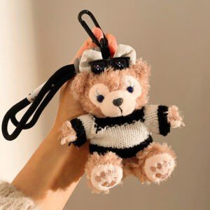 Cute Monkey Plush Toy Keychain in hand of a lady on brownish background