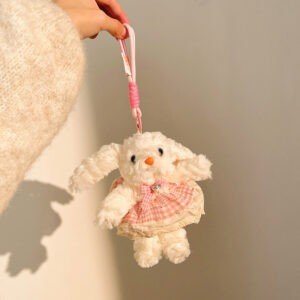 White color Puppy Plush Toy Keychain with lanyard holding hand on decorative background