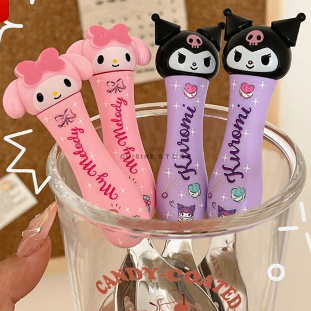 Sanrio themed baby spoon and fork set featuring My Melody and Kuromi characters with soft grip ergonomic handles in a glass.