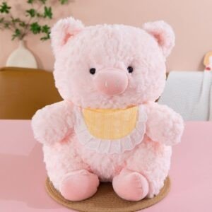 Cute pink pig plush toy wearing a yellow bib.
